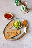 Crackers with avocado dip and sweet chilli jam