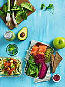 Healthy food: Lunch box with vegetables, salmon, avocado, smoothie with avocado and salad with zucchini and ratatouille