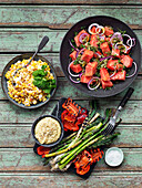 Grilled vegetables with dip, salad with watermelon, corn with chili and coriander