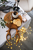 Weihnachtskekse und eine Tasse Kaffee auf Holzbrett in Geweihform