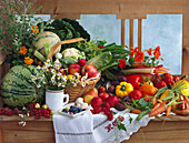 Still life with vegetables, fruit and herbs on a wooden bench