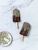 Chocolate ice cream sticks with coloured sugar sprinkles