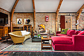 Open, eclectic living room with various sofas and brick wall