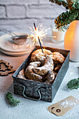 Vanilla crescent biscuits and a sparkler in an old metal box