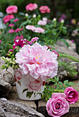 Frühsommer-Gesteck mit Pfingstrosenblüte, Petunie und Liguster, Rosenblüten