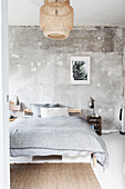 Double bed in bedroom with distressed wall