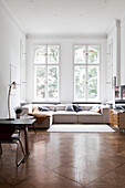 Spacious sofa set in front of windows in old building living room