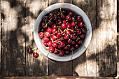 Bowl of organic cherries on a rustic wooden table