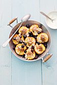 Baked peaches with almonds, blueberries and marzipan balls