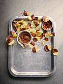 Potato chips with chilli flakes and chocolate icing on a tray