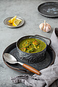 Traditional vegetarian Indian Punjabi food Palak Paneer with spinach and cheese in vintage metal bowl
