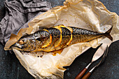 Whole mackerel with lemon and herbs baked and served on baking paper