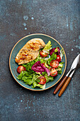 Grilled chicken breast fillet with vegetables salad of fresh tomatoes and salad leaves