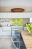 Küche und Essbereich mit Holztisch und Klassikerstühlen unter Oberlicht