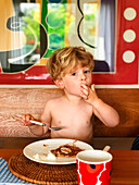 Little boy eating pancakes