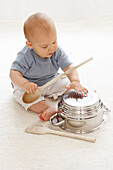 Baby boy playing with colander and spoon