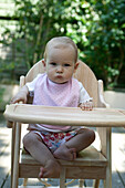 Baby girl sitting in high chair