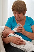 Woman feeding baby boy with bottle
