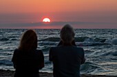 Couple watching the sunset over Lake Michigan, USA
