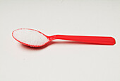 Plastic red teaspoon with sugar