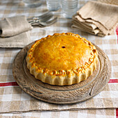 Pork and apple picnic pie on wooden plate