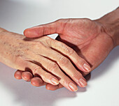 Older woman's hand held gently in man's hand