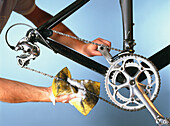 Man using sponge and soapy water to clean bicycle chain