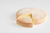 Whole round and slice of French Munster AOC cow's milk cheese