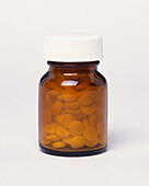 White tablets in brown glass bottle