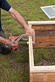 Man constructing cold frame