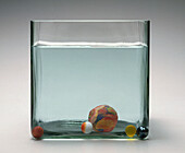 Plasticine ball and marbles in tank of water