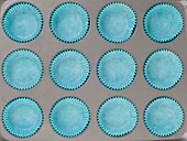 Blue cake cases on stainless steel non-stick baking tray