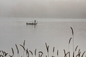 Fisherman on a foggy lake