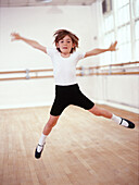 Young male dancer leaping across a dance studio