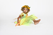 Girl in yellow fairy dress with fake wings on her back