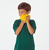 Boy washing his face with a yellow flannel