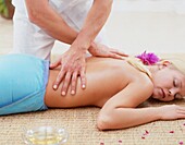 Masseur massaging a woman's back