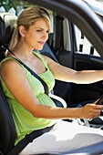 Pregnant woman in car wearing seat belt