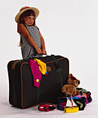 Young girl struggling to carry a very large suitcase