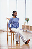 Woman sitting on chair with one leg out in front