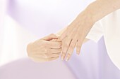 Reflexologist using right thumb to walk down side of finger