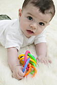 Baby boy playing with plastic ring toy