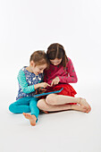 Two sisters using tablet