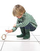 Boy crouching next to roll of tape