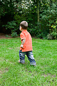 Baby boy walking in garden