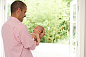 Father holding baby girl by supporting her head