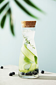 Summer infused water in a trendy bottle with cucumber, blackberry and thyme