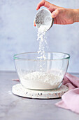 Putting flour and baking powder in a bowl