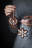 A baker holding a gingerbread cookie ornaments