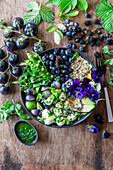 Berry avocado bowl with quinoa, green tomotoes and green herbs oil